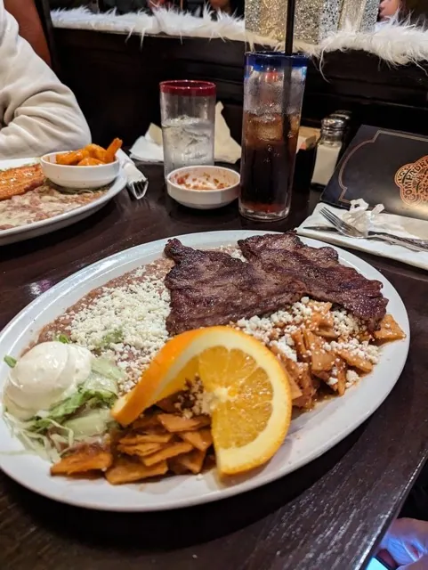 Red chilaquiles breakfast plate with carne asada